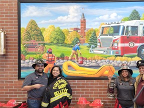 The owners of Firehouse Subs' Belleville location pose in front of the restaurant's mural, which depicts city firefighters deploying a rescue sled. From left are Rohan Tank, Anjali Prajapati, Pritvanti Patel and Aadipkumar Pandya.