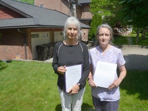 Lynda Montgomery, left, and Linda Perks with their petition calling on Owen Sound council to ban non-owner occupied short-term rentals in areas of the city that are zoned residential on Tuesday, June 14, 2022. The two are standing in front of a property on 4th Street West that Montgomery said is being rented out to large groups of tourists who have partied late at night.