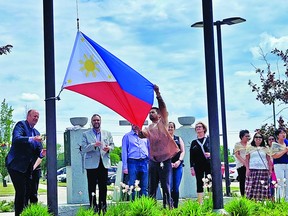 Mayor Bob Young raises the Filipino Flag outside of Leduc City Hall for the first time, June 12. (Jenifer Santiago)