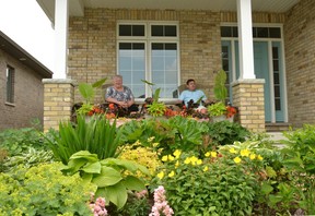 Katherine Robertson and Ross Crawford sit on the porch and enjoy their front garden at Stratford on Blowes Drive. (Galen Simons / The Beacon Herald)