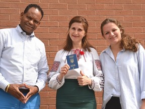 The Multicultural Association of Perth Huron is hosting a World Refugee Day barbeque at the Falstaff Family Centre June 20 to introduce local refugee families, including a few recent arrivals from Ukraine, to the wider community and each other. Pictured are multicultural association executive director Dr. Gezahgn Wordofa, Ukrainian refugee Vera Furman holding her Ukrainian passport and emergency travel visa, and association regional coordinator Nicole Blaine. (Galen Simmons/The Beacon Herald)