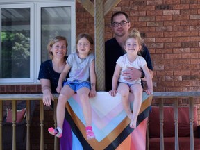 Alisha Stubbs, left, stands with her husband Clayton and their two kids, Zoey, 7, left, and Quinn, 5, next to their Pride Progress flag at their Norwich home.  The family has teamed up with other residents to show support for the LGBTQ-plus community following a string of anti-pride incidents there and elsewhere in Oxford County.  (Calvi Leon/The London Free Press)