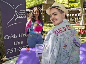 Mabe Kyle (right) of Brant County sports a message-laden jacket while chatting with Renu Dhaliwal of the Sexual Assault Center of Brant at the Pride in the Park event at Mohawk Park on Saturday.