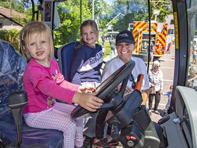 Norfolk County mayor Kristal Chopp watches as Skyler Donaldson, age 4 (left) and her sister Scarlett, 7, check out the cab of a New Holland farm tractor on Saturday June 18, 2022 during the Touch-a-Truck event at the arena in Waterford.