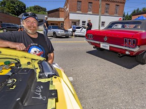 Dan Walsh of Mount Pleasant shows the signature of iconic automotive engineer Jack Roush on the radiator shroud of his 2003 Mustang Roush on Saturday June 18, 2022 during a Mustang car show in downtown Delhi.