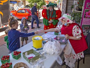 Scarlett Hillman, 8, of Ingersoll receives free strawberry ice cream from Faryn Burch, age 9 of Delhi during Norfolk Community Day on Saturday in Delhi, Ontario.