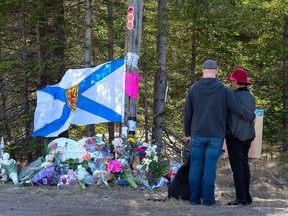 A couple pays their respects at a roadblock in Portapique, N.S., on April 22, 2020, just days after a deadly shooting rampage there saw 22 people killed and several properties destroyed by fire.  Andrew Vaughan/THE CANADIAN PRESS