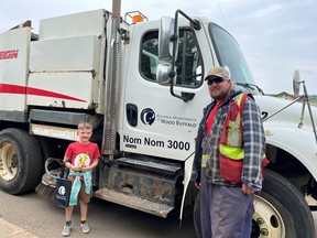 Naming contest winner Nolan (Grade 2) of Dr. K.A. Clark Public School) poses in front of "Nom Nom 3000" the street sweeper, with Brad Little. Supplied Image/RMWB