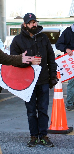 Arthur Kicknosway holds a sign in front of the GO-Vaxx Mobile Vaccine Clinic in Ontario on November 1, 2021 while it was at the Petrolia Farmers' Market. (Terry Bridge/Sarnia Observer)