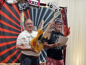 Children's Treatment Centre Foundation of Chatham-Kent president Mike Genge, left, and auctioneer Greg Hetherington, are seen here during the live auction portion of the 21st annual Festival of Giving, which raised $160,800 on Saturday night. (Supplied photo)
