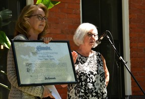 Chairman of Heritage Stratford Cambria Ravenhill and the Hon.  Dr James Palmer Rankin's great-granddaughter Adrian Hey shows those gathered at a Blue Plaque awards ceremony on Tuesday the original sheepskin certificate Rankin received when he was named to the Senate of Canada in 1925. (Galen Simmons/The Beacon Herald)