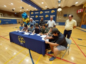 Chatham-Kent Secondary School graduating students, from left, Drake Duplessis, Dylan Purdy, Nathan Johnson, Ethan Purdy, Carson Parry, Taylor Ball and Caley Whiteye, signed agreements for apprenticeship positions on June 23 with local companies. Pictured in back, from left, are Dale MacDonald, of Honey Electric, Travis Peters owner of The Shop, John Veenema, body shop manager at Heuvelmans Chevrolet Buick GMC Cadillac in Chatham, and Carl Powers, vice-president of operations with AWC Manufacturing in Tilbury. PHOTO Ellwood Shreve/Postmedia Network