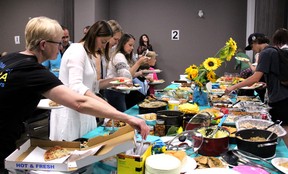 People fill their plates with food during a potluck and community appreciation dinner welcoming newly arrived Ukrainian families Friday, June 24, 2022 at the Unifor building in downtown Fort McMurray. Laura Beamish/Fort McMurray Today/Postmedia Network