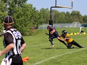 A player slips through a tackle at William F. Lede Park June 26 as part of the LDMFA’s 11th annual Football Jamboree. (Leduc and District Minor Football Association)