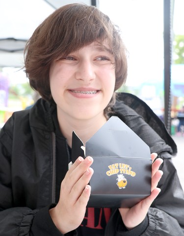 Julian Huff, from the Chicago-area, enjoys his first sample of double cheeseburger bacon poutine in his life  at Poutine Feast in Sault Ste. Marie, Ont., on Friday, June 30, 2022. (BRIAN KELLY/THE SAULT STAR/POSTMEDIA NETWORK)