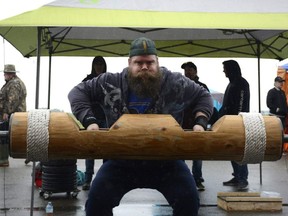 Adam Duerr, strongman athlete demonstrates sheer strength June 18 at Full Tilt Mechanical Ltd. in Clairmont.