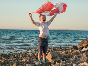 Young boy holding flag of Canada. Canadian National Holiday 1 July.