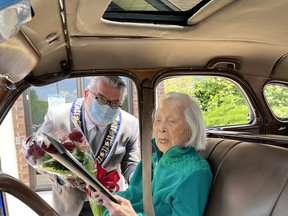 Stella Bullen, 106, accepts a bouquet of flowers and a certificate of congratulations from Brant Mayor David Bailey as part of her whirlwind Paris tour in celebration of her auspicious birthday last week.