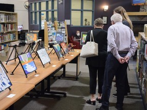 Attendees of the Airdrie Public Library's High School Art Gala take a look at some of the pieces on display on June 11. Photo by Riley Cassidy/The Airdrie Echo/Postmedia Network.