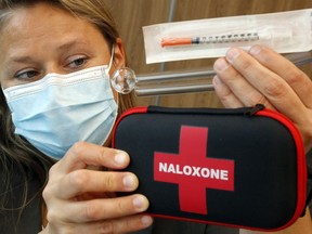 Program manager Stephanie McFaul, holds, from top to bottom, a syringe, a a methamphetamine pipe, and a crack pipe - all for single use - and a naloxone kit Wednesday at Hastings Prince Edward Public Health in Belleville. The distribution of such items is part of the health unit's harm-reduction program.