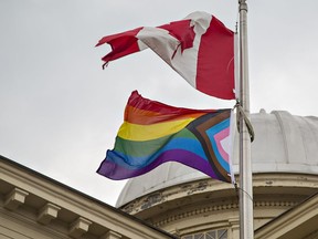 A Progressive Pride flag flies beneath the Canadian flag at Laurier Brantford's Carnegie building in downtown Brantford on Wednesday.