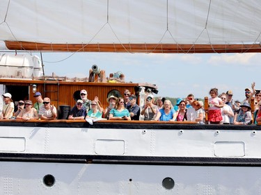 Passengers on the Empire Sandy's Parade of Sail cruise wave to spectators on shore. (RONALD ZAJAC/The Recorder and Times)