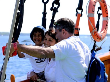 Kishor Belkhode, right, of Ottawa, takes a photo with his wife, Shoba, and son Dilan aboard the Empire Sandy on Saturday. (RONALD ZAJAC/The Recorder and Times)