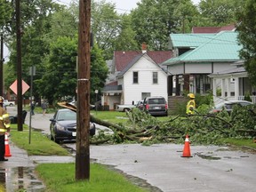 Chatham firefighters were on the scene after a large section of a tree fell across Lorne Avenue in Chatham, taking down a power line when a severe storm quickly blew through on Wednesday afternoon.  PHOTO Ellwood Shreve/Chatham Daily News