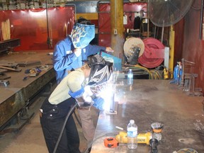 Taylor Ball, 18, a Grade 12 student at Chatham-Kent Secondary School, receives some guidance from Corey St. Peter before taking part in a welding competition at AWC Manufacturing in Tilbury on Wednesday. PHOTO Ellwood Shreve/Chatham Daily News