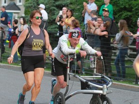 Walker racer Bob Hardy, late in his event at the Ottawa Race Weekend, getting assistance from Joanne Merritt of the Extra Mile Group that assists participants near the finish line. Handout/Cornwall Standard-Freeholder/Postmedia Network