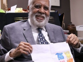Local psychiatrist Dr. Claude Manigat holds up his favourite retirement gift he received from a patient in his office. on Thursday June 9, 2022 in Cornwall, Ont. Laura Dalton/Cornwall Standard-Freeholder/Postmedia Network