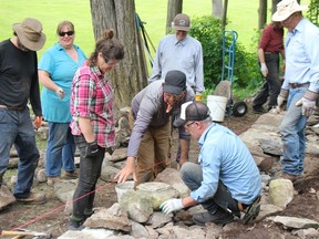 Dry Stone Canada's Scott Young (dark cap, grey shirt) providing instructions during a weekend workshop session. Photo on Sunday, June 12, 2022, in St. Raphael's, Ont. Todd Hambleton/Cornwall Standard-Freeholder/Postmedia Network