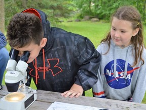 From left, Zachary and Amelia Jacobs having fun with the citizen scientist section at Cooper Marsh Visitor's Centre grand reopening on Saturday June 18, 2022 in South Glengarry, Ont. Shawna O'Neill/Cornwall Standard-Freeholder/Postmedia Network