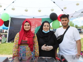 Pessoas servem comida em um estande representando o Afeganistão no Dia do Multiculturalismo, organizado pela Associação Multicultural Wood Buffalo, no Fort McMurray Heritage Village no sábado, 11 de junho de 2022. Laura Beamish/Fort McMurray Today/Postmedia Network