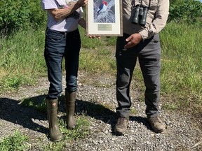 Denice Wilkins, a board member for the Quinte Field Naturalists, presents Kurt Hennige with the Ontario Nature Natural History Award at the Camden East Alvar property on June 17, 2022. Brigid Goulem/The Kingston Whig-Standard/Postmedia Network