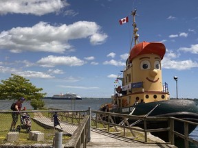 Theodore the Tugboat at Marine Museum of the Great Lakes as the Ocean Explorer cruise ship floats behind it in Kingston on Friday. Theodore will be in the city until June 23.