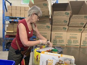 Judy Fair, a volunteer at the Partners In Mission Food Bank, preparing food packages for distribution on Wednesday, June 22.