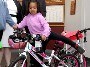 Six-year-old Journie Brown gets on her new bicycle at the YMCA of Eastern Ontario in Kingston on Friday, June 10, 2022. Journie received the bike from the executive MBA students at the Smith School of Business at Queen's University, Canadian Tire's Jumpstart program and the local YMCA.