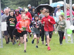 Runners in the 2k event at the Krista Johnson Memorial Run head out onto the rain-drenched course on Sunday morning, June 12. Anthony Dixon
