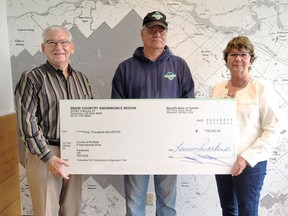 The County of Renfrew recently received a donation of $40,000 from Snow Country Snowmobile Region and the Timberline Snowmobile Club towards work on the Algonquin Trail through the City of Pembroke. Taking part in the cheque presentation (from left) were Councillor Robert Sweet, chairman of the Development and Property Committee; Kerry MacDonald, president of the Timberline Snowmobile Club and Warden Debbie Robinson, County of Renfrew.