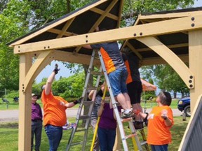 Members of Team Home Depot work to assemble a gazebo at Pembroke's new Waterfront Arboretum.