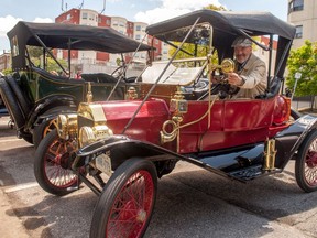 Kim Baechler, vice president of the Horseless Carriage Club of America's Ontario branch, adjusts the mirror on his 1911 Ford Model T Torpedo Runabout. Many of the club's 95 members stopped in a parking lot on Cobourg Street, part of a three-day tour that also included nearby towns St. Jacobs and Elora. "We're kind of like a living museum," Baechler said. ""There are always people that like to see (these cars) and this is what it's all about -- to show people what it was like back in the day."