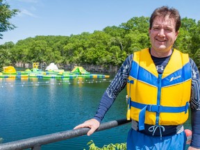 St. Marys Mayor Al Strathdee stands on a diving platform at the St. Marys Quarry.  In the background is the popular swimming spot's latest addition, an inflatable waterpark opening for the first time Saturday.  Chris Montanini/Stratford Beacon Herald