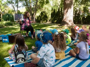 Trish MacGregor, coordinator of children's programs at Stratford Public Library, reads a story to a kindergarten class at Shakespeare Public School in Shakespearean Garden.  (Chris Montanini/Stratford Beacon Herald)
