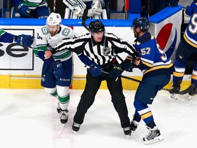 Linesman Brad Kovachik gets between Tyler Motte of the Vancouver Canucks and David Perron of the St. Louis Blues during the third period in Game Five of the Western Conference first round during the 2020 NHL Stanley Cup Playoffs at Rogers Place on Aug. 19, 2020 in Edmonton.