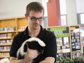 Nick Smith, with Heaven's Wildlife Rescue, is shown in this file photo holding a skunk named Stinkerbutt during a presentation at the Sarnia Library.