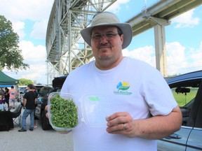 Brian Drulard, of Sarnia's Green Micro Farms, holds a container of its miniature vegetables at the first Moonlight Farmers' Market of the season in Point Edward. The market runs Thursdays, 4 p.m. to 8 p.m., next to the Blue Water Bridge in Waterfront Park.