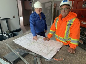 Mike Kloepfer, of Titan Trailers and Dave Holmes, of Titan Trailers, look over plans to transform the former research station near Delhi into transitional housing for immigrant and refugees from Ukraine and possibly Afghanistan. The work is being done by Reid & Deleye of Courtland.  VINCENT BALL