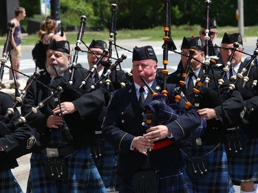 Members of the Greater Sudbury Police Pipes and Drums march in a funeral procession for Greater Sudbury firefighter Mike Frost in downtown Sudbury, Ont. on Wednesday June 1, 2022. His obituary said, "It is with deep sorrow and great sadness that the family of Mike Frost announce his unexpected death at his residence on May 19, 2022, at the age of 40." John Lappa/Sudbury Star/Postmedia Network