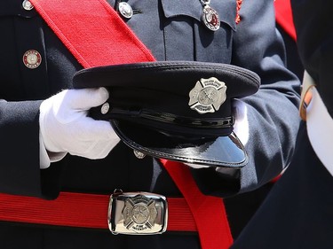 A member of the Greater Sudbury firefighters honour guard holds the hat of Greater Sudbury firefighter Mike Frost at a funeral procession in downtown Sudbury, Ont. on Wednesday June 1, 2022. John Lappa/Sudbury Star/Postmedia Network